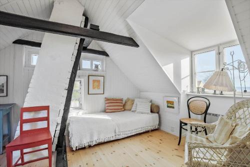 una habitación blanca con una cama y una silla en 5585-Svaneke-Helgolandsgade-7-B, en Svaneke