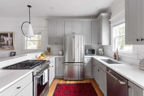 a kitchen with white cabinets and a stainless steel refrigerator at Best in Show in Atlanta