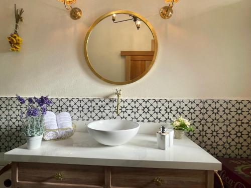 a bathroom with a bowl sink and a mirror at Hotel Lago Valdivia in Jardin
