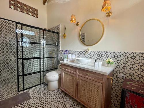 a bathroom with a sink and a toilet and a mirror at Hotel Lago Valdivia in Jardin