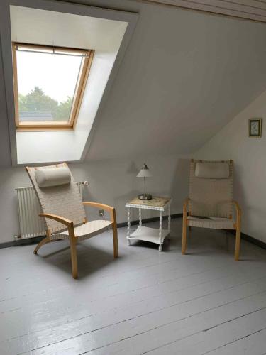 a room with two chairs and a table and a window at Købmandsgården i Blære in Års