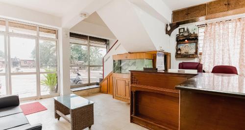 a living room with a piano and a large window at Super Hotel O Sushma Lodge in Manipala