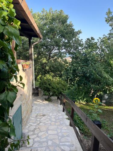 a stone walkway next to a building with a wooden fence at A casa di Giovanni apartment in Albano di Lucania