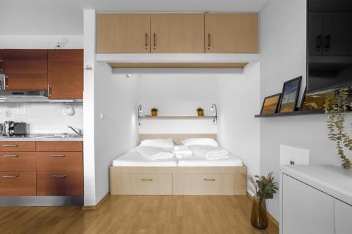 a small kitchen with a bed with towels on it at Apartmán Klínovec 365 in Loučná pod Klínovcem
