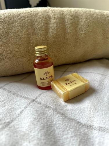 a bottle of honey and a bar of butter on a bed at Friendly Family Home Stay in Peterborough