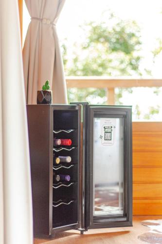 a small refrigerator with its door open next to a window at Cabana Romântica na Serra com Hidro, Lareira, Lagos e Trilhas in Bom Retiro