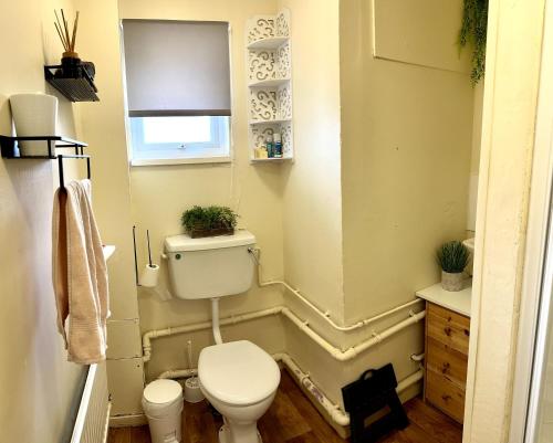 a small bathroom with a toilet and a window at Friendly Family Home Stay in Peterborough