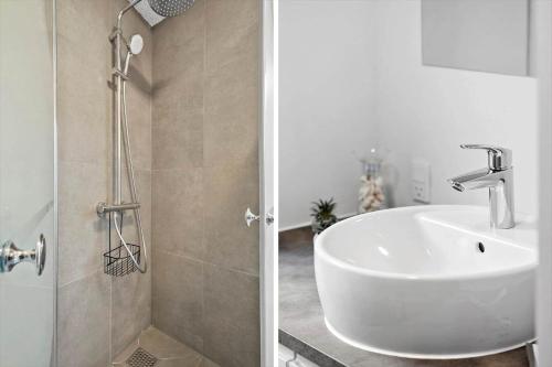 a bathroom with a white sink and a shower at OH333-Storvorde-Frydenstrand-56 in Storvorde