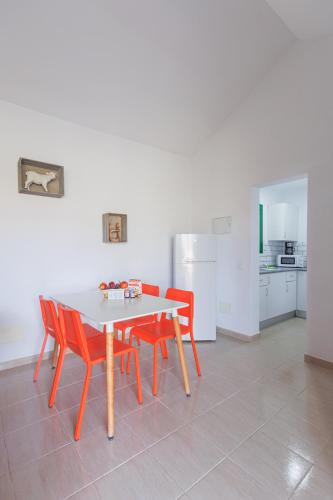 a kitchen with a table and four red chairs at Blue Río Playa, Casa & Studio in Costa Calma