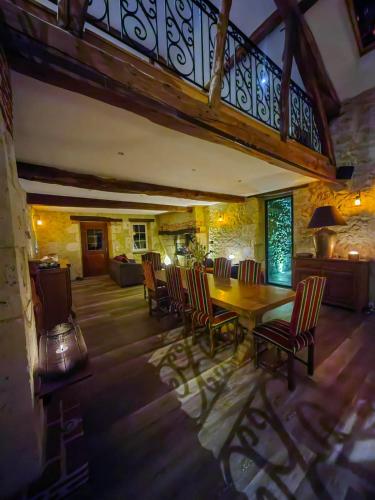 a dining room with a wooden table and chairs at Domaine de Pourrouquet - Demeure de charme et Gîte in Vic-Fezensac