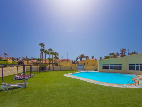 a swimming pool in a yard next to a building at Blue Río Playa, Casa & Studio in Costa Calma
