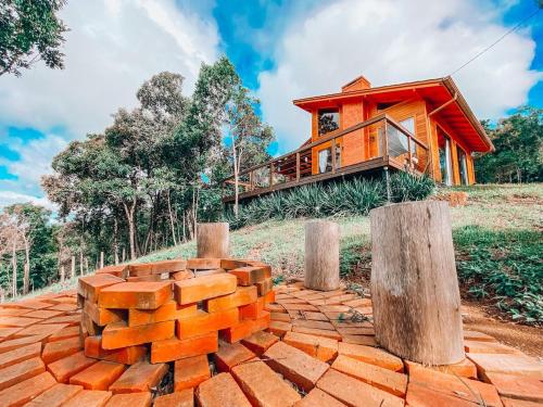 a house on a hill with a pile of bricks at Cabana Romântica na Serra com Hidro, Lareira, Lagos e Trilhas in Bom Retiro