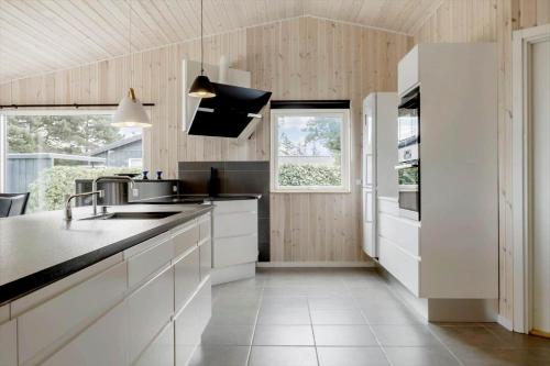 a kitchen with white cabinets and a black counter top at OH467-Storvorde-Birke-Alle-15 in Storvorde