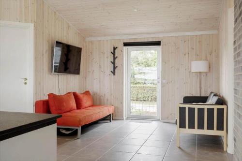 a living room with a orange couch and a window at OH467-Storvorde-Birke-Alle-15 in Storvorde
