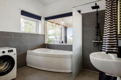 a bathroom with a tub and a sink and a washing machine at OH467-Storvorde-Birke-Alle-15 in Storvorde