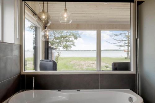 a bath tub in a bathroom with a large window at OH467-Storvorde-Birke-Alle-15 in Storvorde