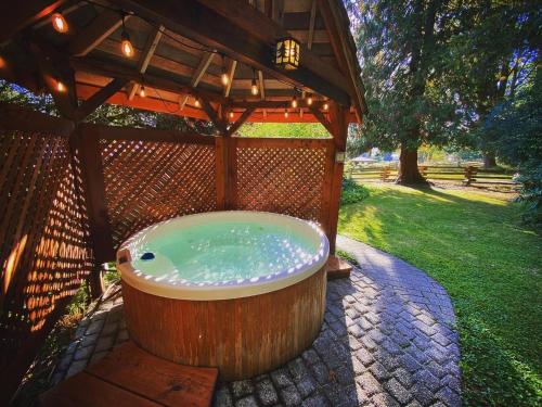 a large wooden bath tub in a gazebo at Emmons Suite at Ashford Lodge: Hot Tub, Projector! in Ashford