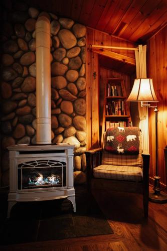 a living room with a fireplace and a chair at Emmons Suite at Ashford Lodge: Hot Tub, Projector! in Ashford