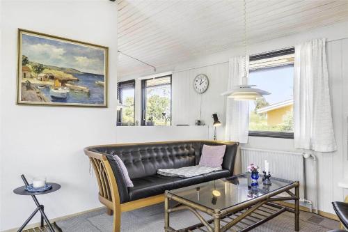 a living room with a leather couch and a table at 3656-Nexo-Olssonsvej-8 in Neksø