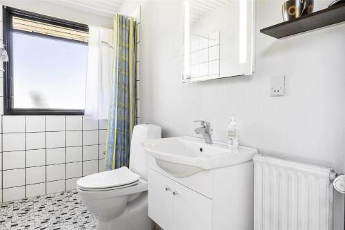 a white bathroom with a toilet and a sink at 3656-Nexo-Olssonsvej-8 in Neksø