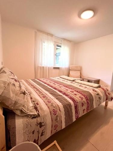 a bedroom with a bed with a blanket on it at Casa vacanze Ai Denat in Lamon