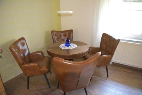 a dining room table and chairs with a blue vase on it at Ferienwohnung am Netzener See in Netzen