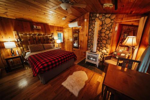 a bedroom with a bed and a fireplace in a cabin at Emmons Suite at Ashford Lodge: Hot Tub, Projector! in Ashford