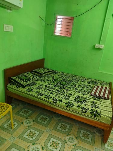 a bed in a room with a green wall at shan mantion in Vellore