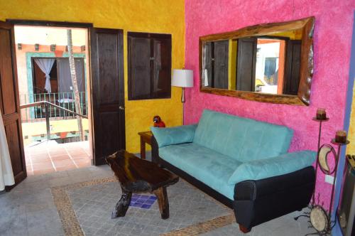 a living room with a couch and a mirror at Hacienda Maria Bonita Hotel in Playa del Carmen