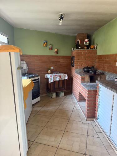 a kitchen with a stove and a brick wall at Chácara com piscina e churrasqueira in Itatiba