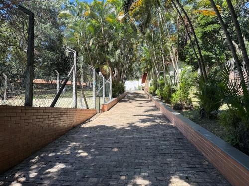 a brick walkway with palm trees in a park at Chácara com piscina e churrasqueira in Itatiba