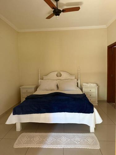 a bedroom with a bed with a ceiling fan at Chácara com piscina e churrasqueira in Itatiba