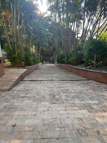 a stone pathway with a bench in a park at Chácara com piscina e churrasqueira in Itatiba