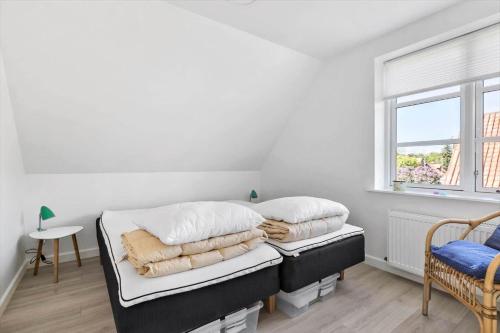 a bedroom with a bed with white sheets and a window at 4790-Ronne-Kanegardsvej-12-1 in Rønne