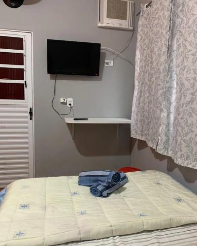a bed with a towel on it in a bedroom at Pousada Fênix,com piscina -250 METROS DA PRAIA in Pontal do Paraná