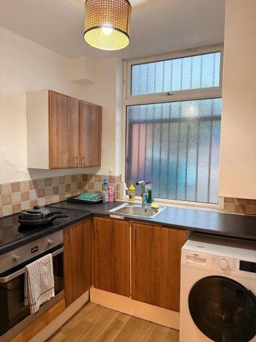 a kitchen with a sink and a window at Oldham city centre studio in Oldham