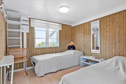 ein Schlafzimmer mit zwei Etagenbetten und einem Mann, der auf einem Bett sitzt in der Unterkunft 6788 Allinge - Gyvelvej 11 A in Allinge