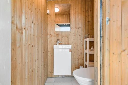 ein Holzbadezimmer mit einer Badewanne und einem Waschbecken in der Unterkunft 6788 Allinge - Gyvelvej 11 A in Allinge