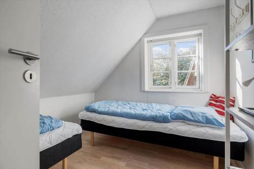 a bedroom with two beds and a window at 6736-Allinge-Thorkildsvej-8 in Allinge