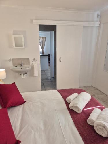 a bedroom with a large bed with towels on it at Paterson Place Studios in Hermanus