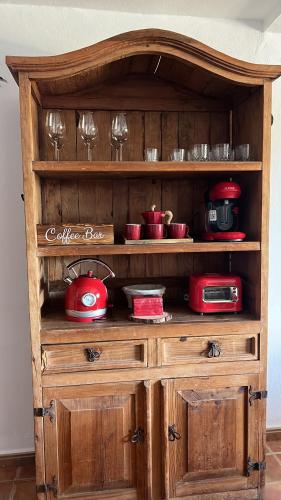 a wooden hutch with dishes and wine glasses on it at Casita Barranco del agua in Yaiza