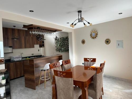 Una cocina y un comedor con mesa y sillas de madera. en Departamento de Estreno Amplio y Confortable, en Ayacucho