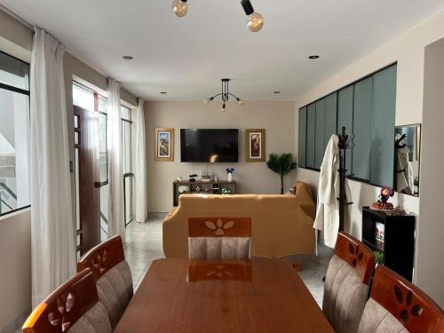 Un comedor con una mesa y un sofá. en Departamento de Estreno Amplio y Confortable, en Ayacucho