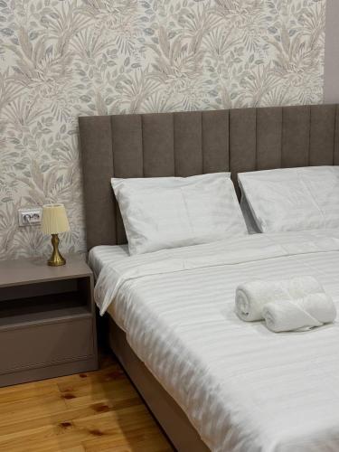 a bed with two white towels on top of it at Hotel 002 in Osh