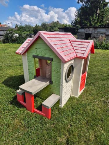 a green and red dog house in the grass at Chez Simone Liège, bain nordique in Boncelles