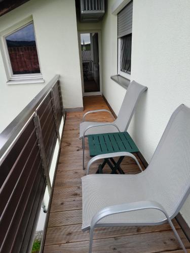 two chairs and a table on a balcony at Ferienwohnung Marianne in Egg