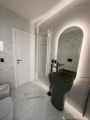 a bathroom with a green toilet and a mirror at Sui Generis Montesilvano Colle in Montesilvano