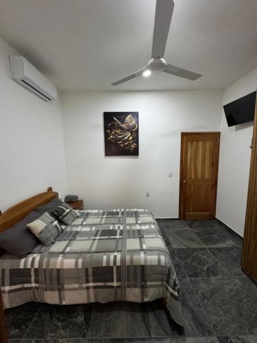 a bedroom with a bed and a ceiling fan at Houzze Plety in Brisas de Zicatela