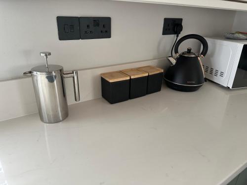 a kitchen counter with a blender and a microwave at Tranquil detached barns in Sherborne St John in Sherborne Saint John