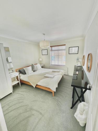 a white bedroom with a large bed and a desk at Heart of Old Portsmouth in Portsmouth